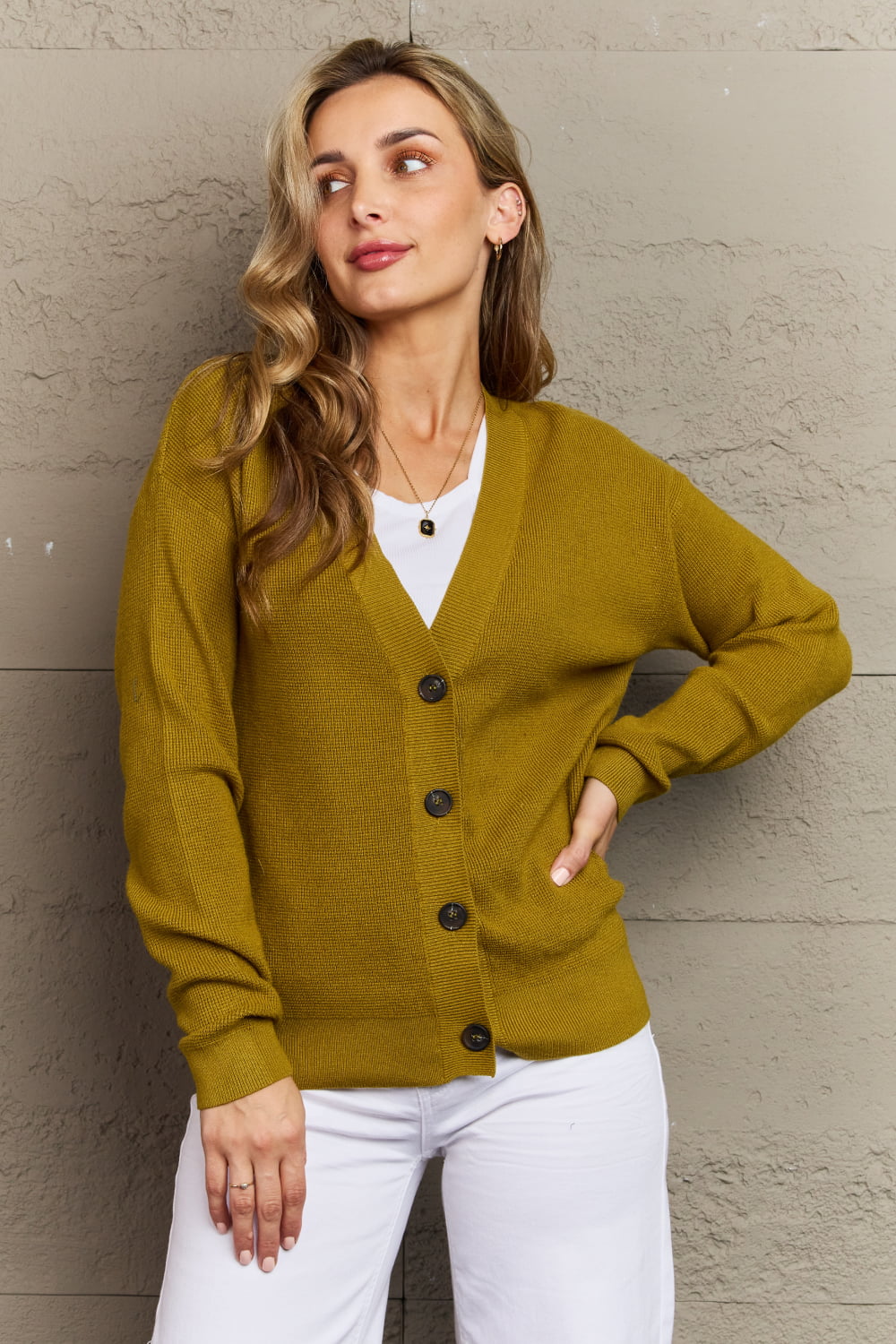 Woman wearing chartreuse V-neck cardigan with long sleeves and button-down style, perfect for a casual look.