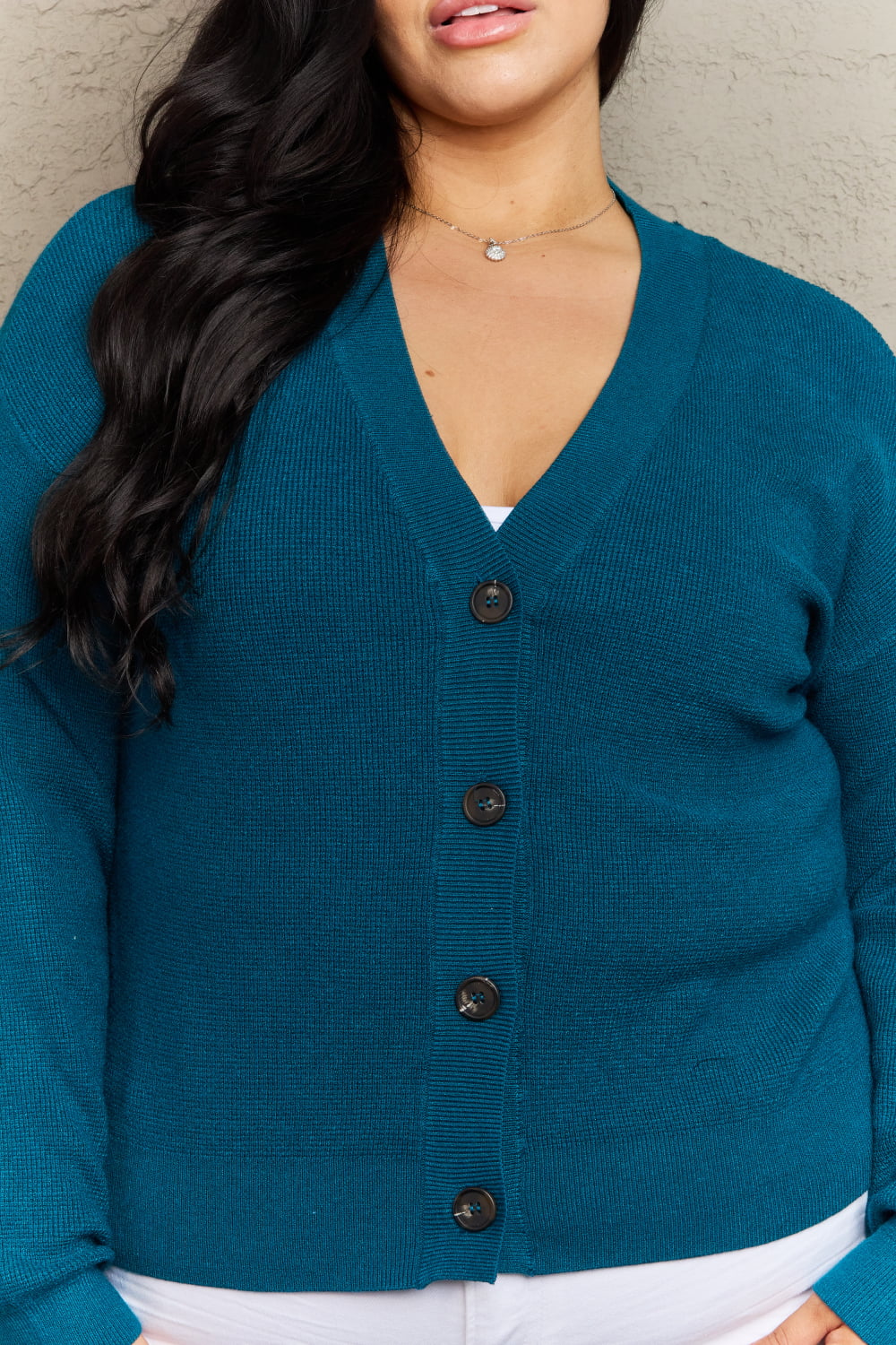 Woman wearing Kiss Me Tonight Full Size Cardigan in teal with V-neck and button-down design, showcasing casual style and ribbed texture.