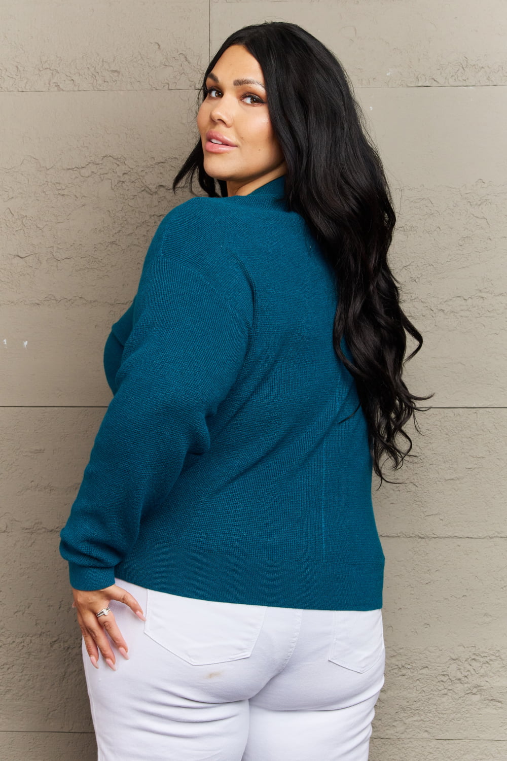 Woman wearing Kiss Me Tonight teal cardigan with long sleeves and ribbed V-neck, styled casually with white pants.