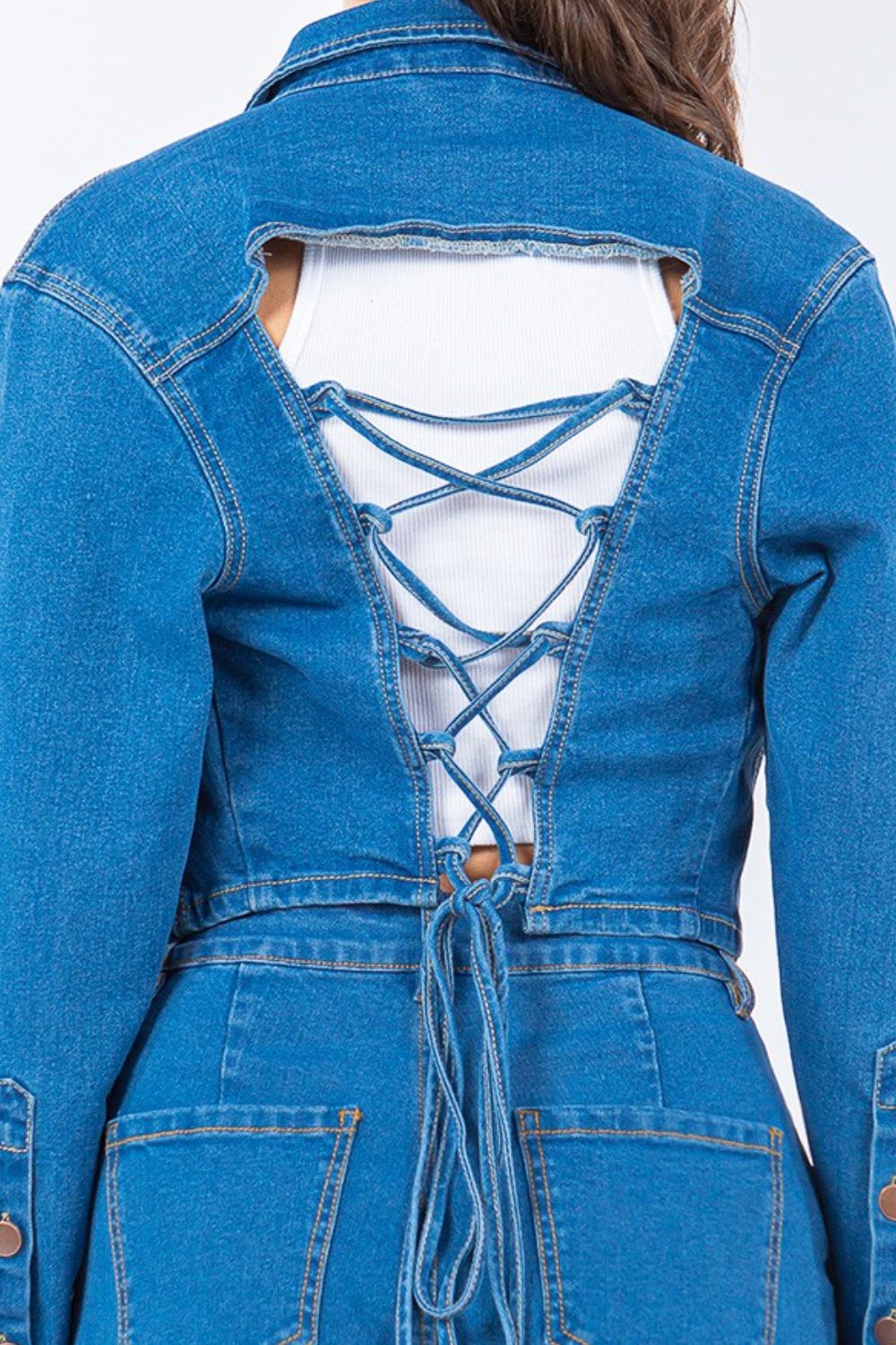 Laced back cropped denim jacket with trendy lace-up design and flattering fit, ideal for versatile casual and dressy outfits.