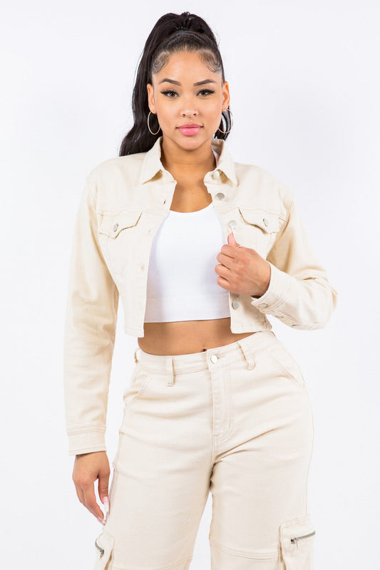 Woman wearing chic laced back cropped jacket in soft cotton blend, styled with matching high-waisted pants, showcasing trendy fashion.