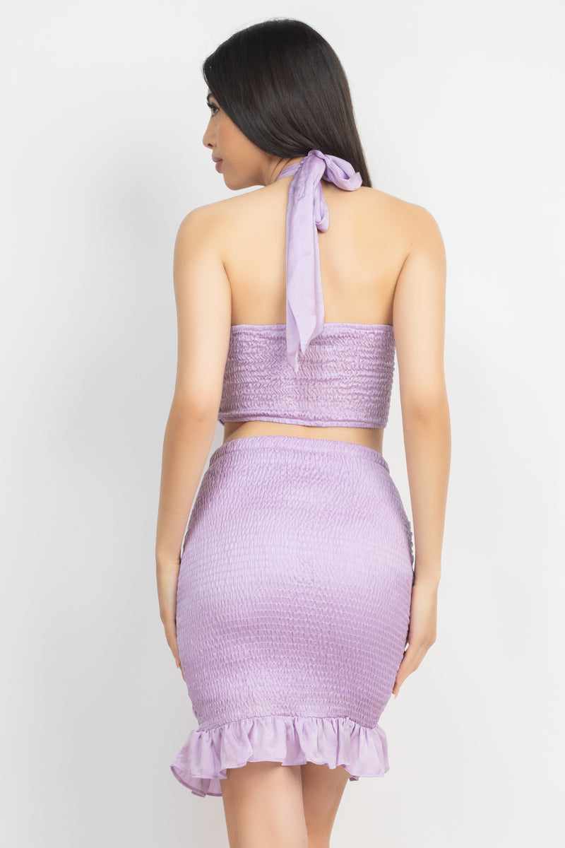 Lavender halter neck crop top and skirt set with open back and ruffled hem, featuring shirred and smocking details in 100% polyester.