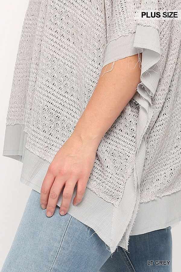 Plus size light grey boxy top with poncho sleeve, close-up of textured knit and woven fabric design.