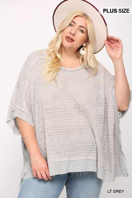 Light grey plus size knit boxy top with poncho sleeve, modeled with a stylish hat.