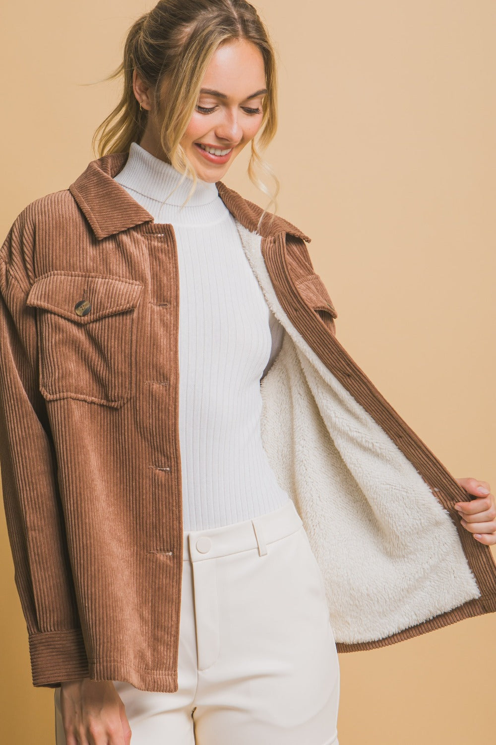 Woman wearing Love Tree corduroy button-up jacket with cozy sherpa lining, showcasing stylish warmth and comfort.