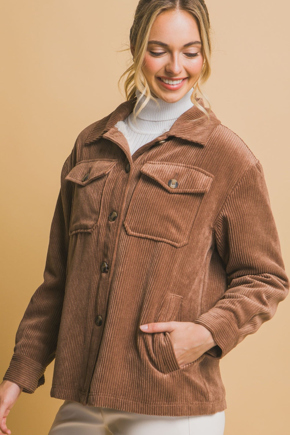 Woman wearing a brown corduroy button-up jacket with cozy sherpa lining, ideal for warmth and style.