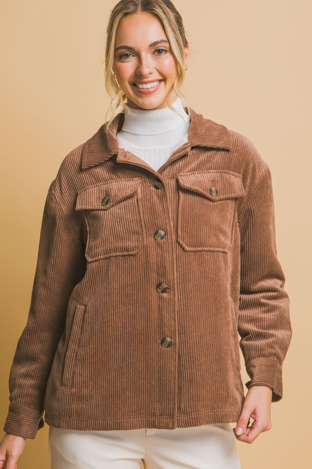 Woman wearing a brown corduroy button-up jacket with sherpa lining, showcasing a stylish and cozy outfit for chilly days.