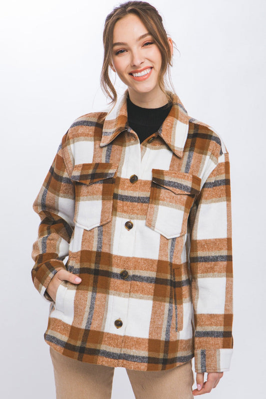 Woman wearing a chic plaid button-up shacket, blending a shirt and jacket style, offers cozy comfort and versatile casual fashion.