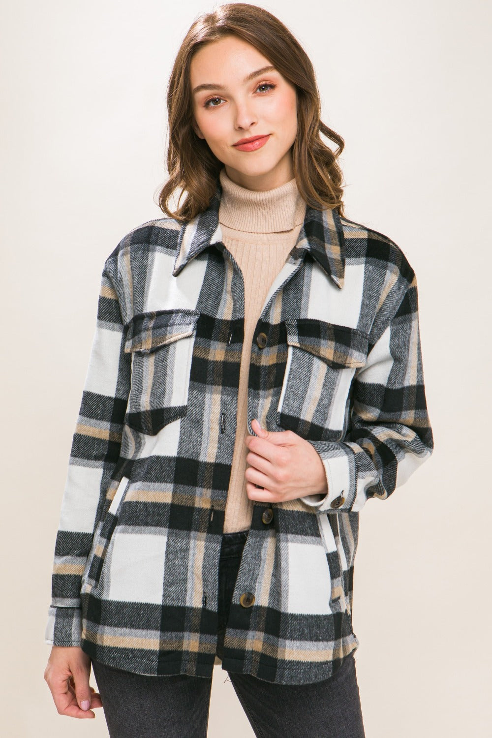 Woman wearing a chic plaid button-up shacket styled with a turtleneck sweater, showcasing a timeless and versatile casual look.