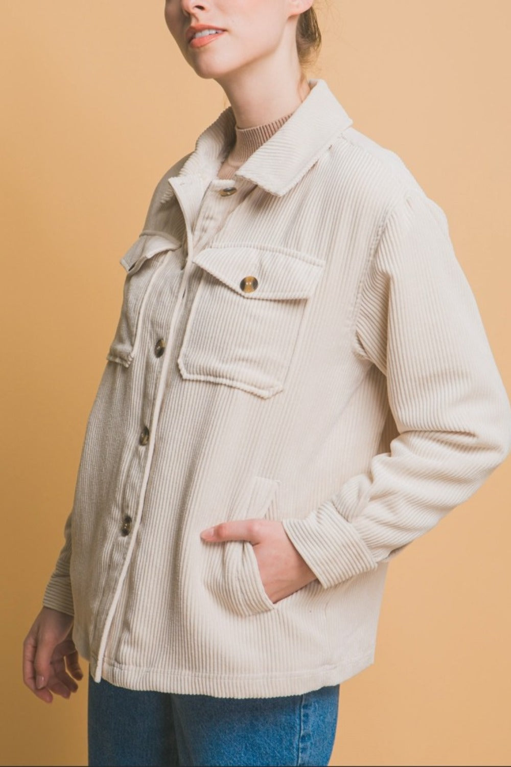 Woman wearing beige Love Tree Corduroy Button Up Jacket with Sherpa Inside, featuring pockets and a relaxed fit.