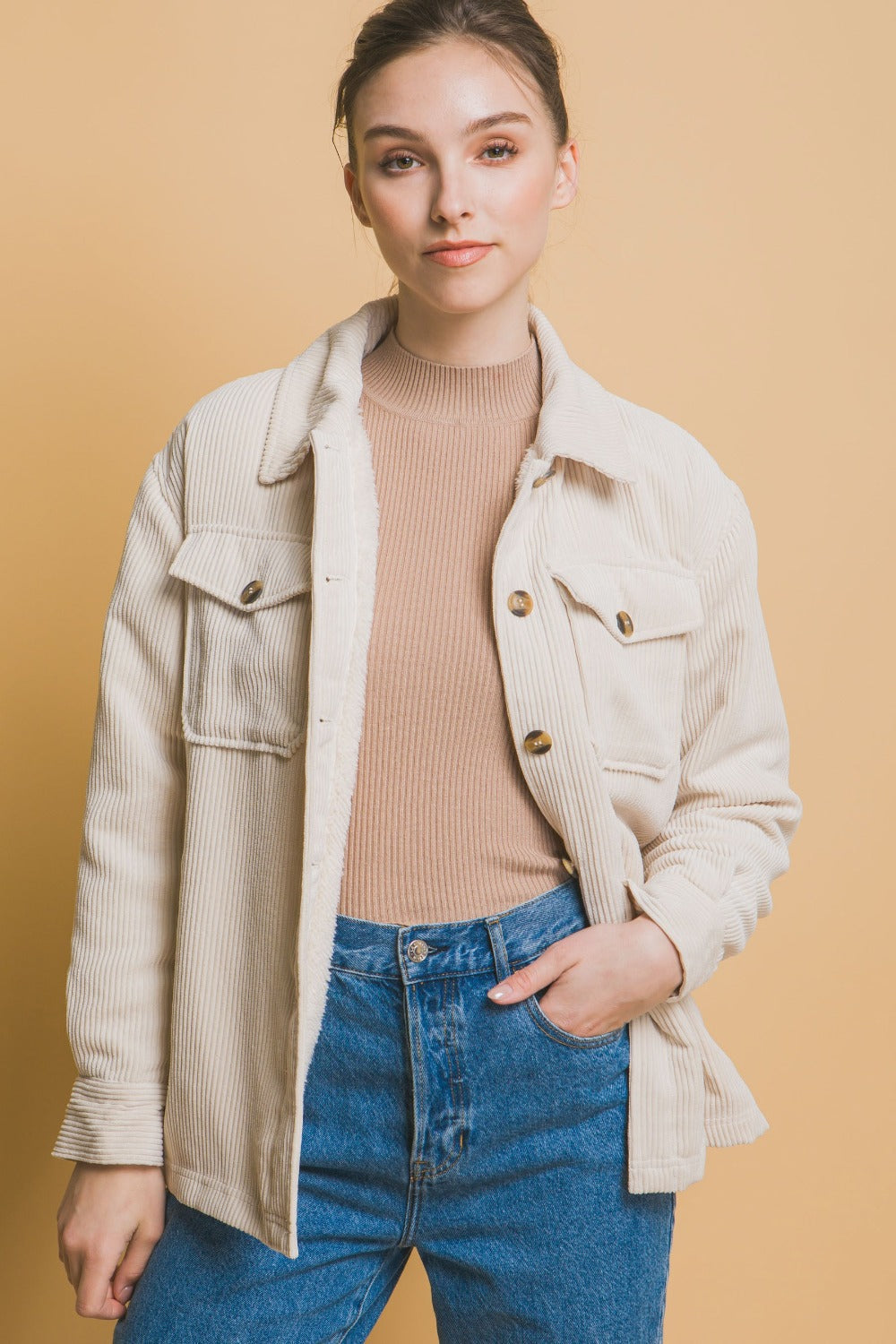 Woman wearing Love Tree Corduroy Button Up Jacket with Sherpa Inside, beige color, styled with casual jeans and top.