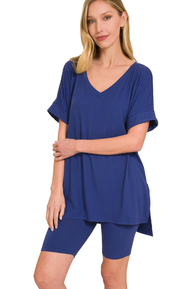 Woman wearing a navy brushed microfiber V-neck top and biker shorts set with a hi-low hem, showcasing soft fabric and perfect stretch.