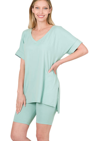 Woman wearing light green brushed microfiber V-neck top and biker shorts set with hi-low hem, showcasing a buttery soft fabric.
