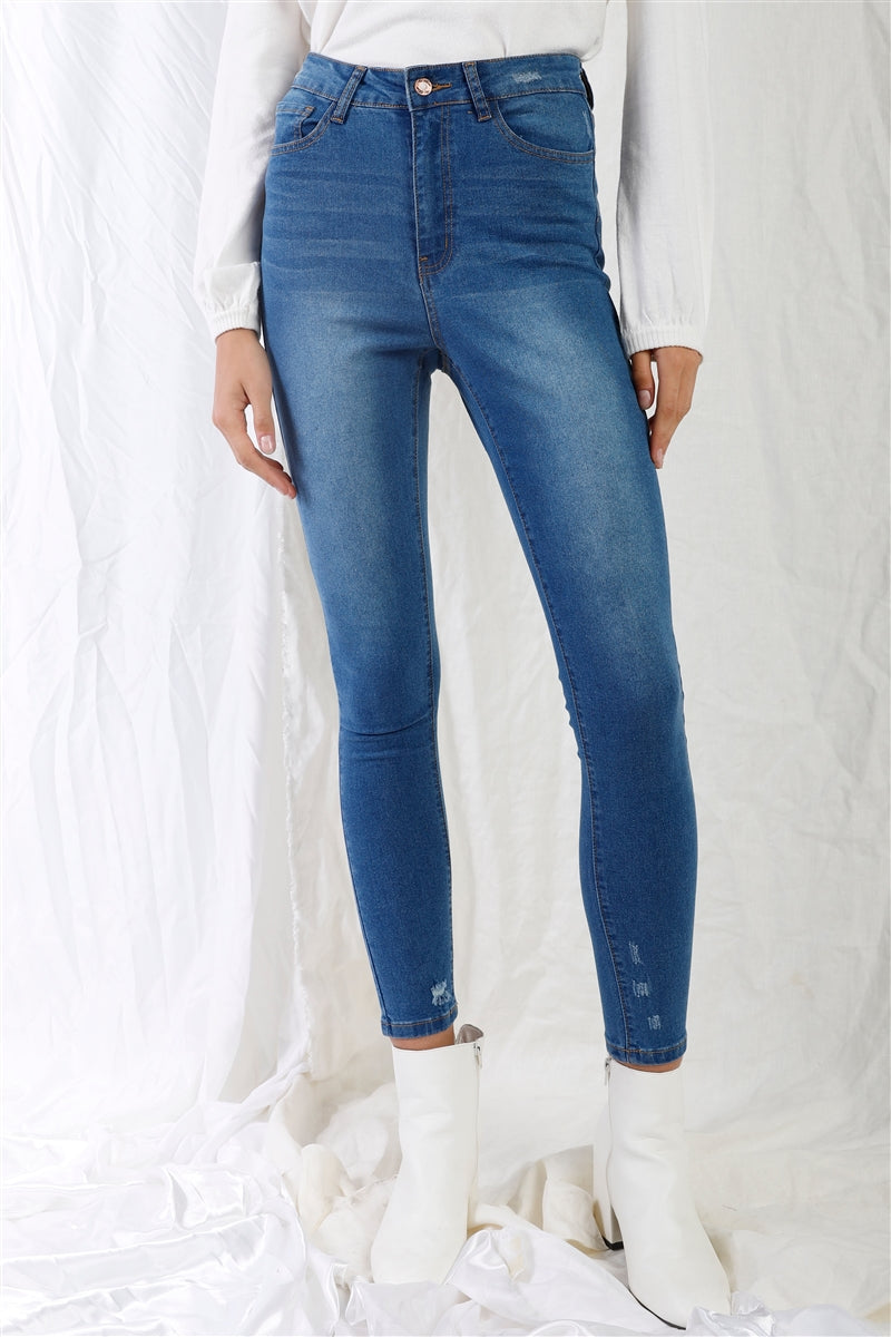 Mid blue high-waisted skinny jeans with small rips, five-pocket design, white boots, showcasing casual stylish fit for all-season wear.