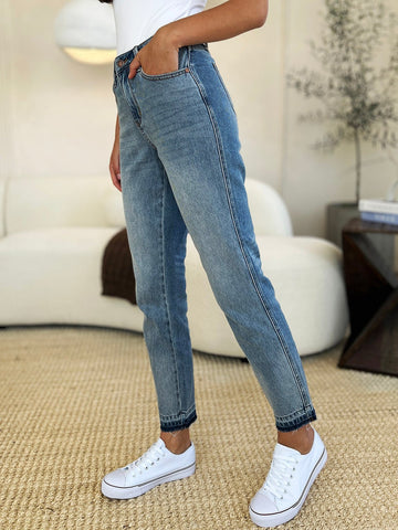 Mid Rise Rigid Magic Release Hem Jeans with moderate stretch, featuring cotton blend for comfort and style in a casual setting.