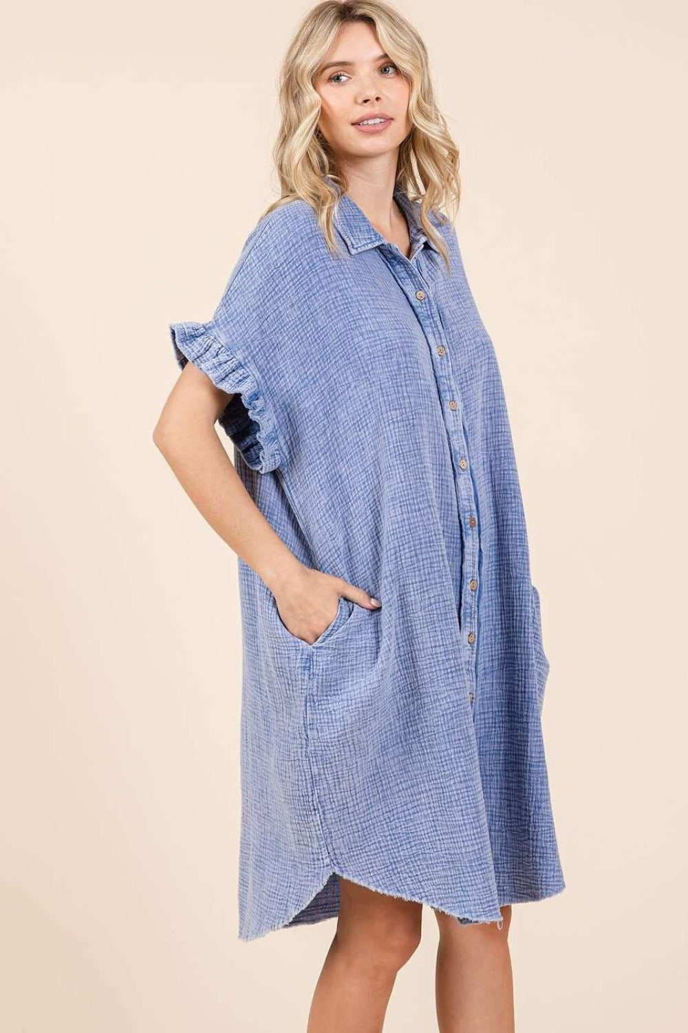 Mineral wash cotton gauze mini shirt dress with buttoned front, ruffled sleeves, and raw hem in blue.