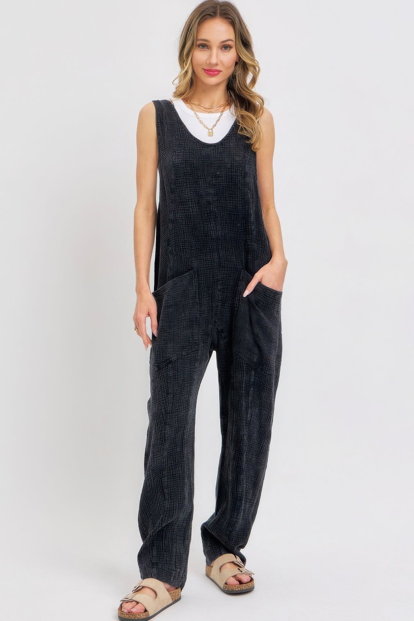 Woman wearing mineral washed summer jumpsuit with oversized pockets and adjustable straps in breathable cotton gauze.