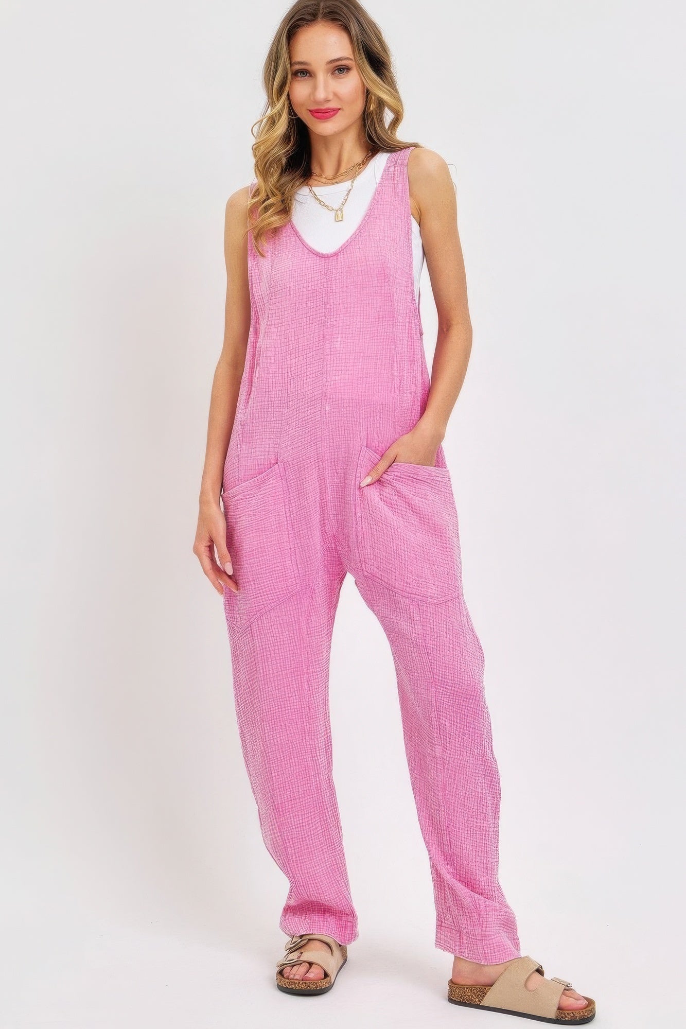 Pink mineral washed summer jumpsuit with adjustable straps and patch pockets, perfect for a relaxed and stylish summer look.