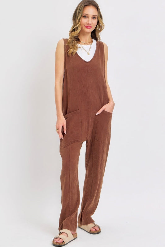 Woman wearing a brown mineral washed summer jumpsuit with oversized pockets and adjustable straps, showcasing relaxed and effortless style.