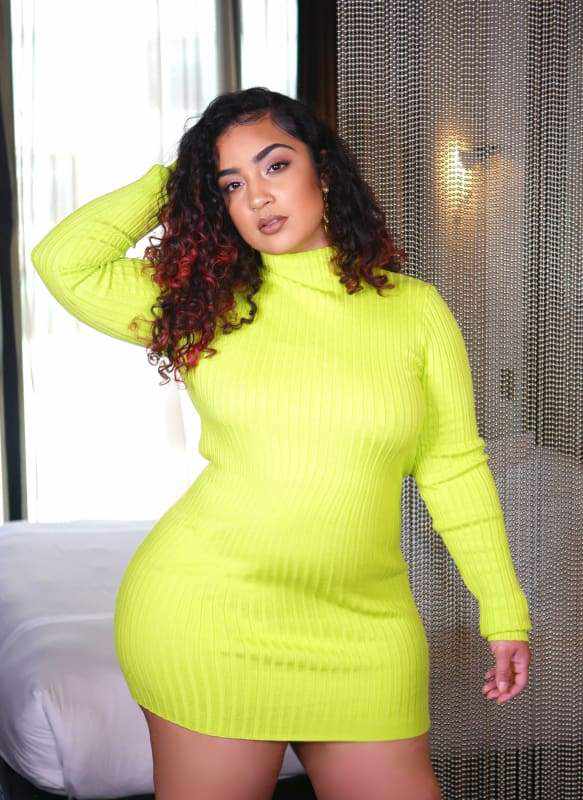 Woman wearing Kissed Lime Green Mini Dress in bright room with chain curtain background.