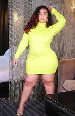 Woman in lime green mini dress, standing with hand on head, highlighting fashion style and comfort indoors.