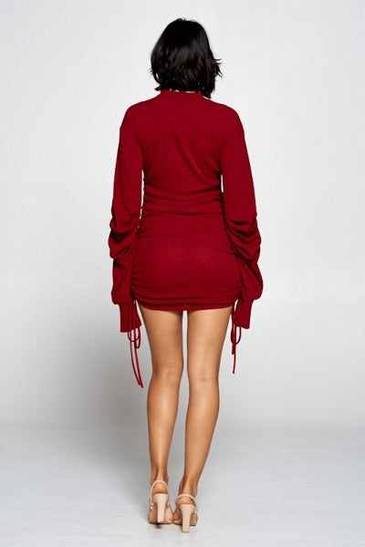 Burgundy mini bodycon dress with mock neck, long sleeves, ruched sides, and drawstrings, made in USA, back view.