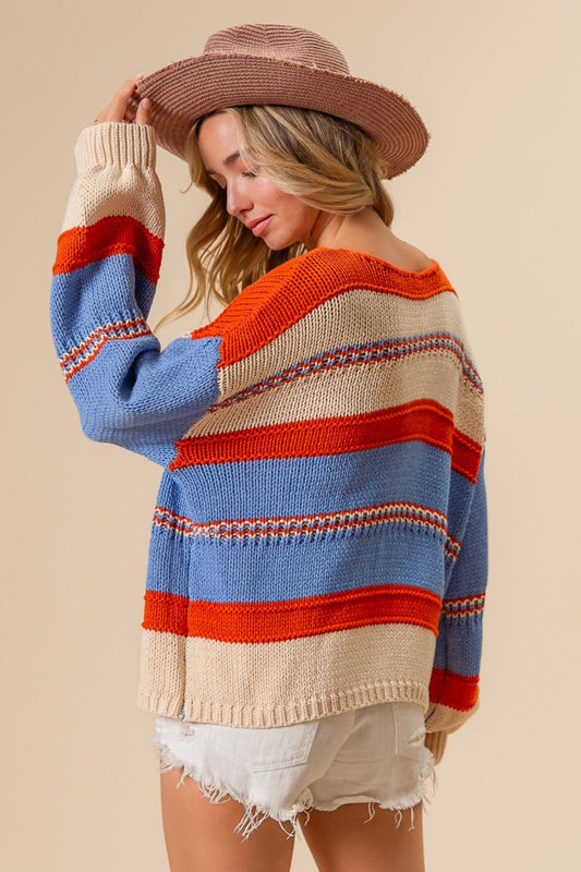 Woman wearing a multi-color stripe scoop neck sweater with a slightly stretchy fit, made from 60% cotton and 40% acrylic.