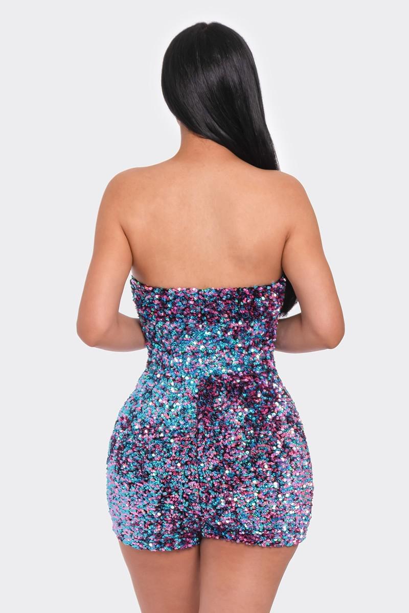 Woman wearing a strapless multi sequins tube top romper with a shimmering blue and pink design, viewed from the back.