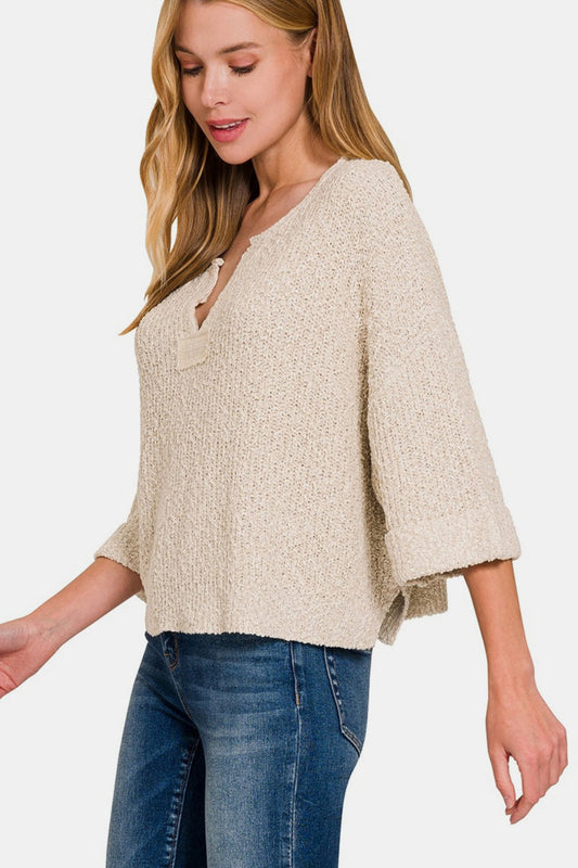 Woman wearing notched side slit patch sweater with short sleeves and jeans, highlighting comfortable and stylish design.