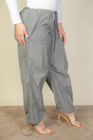 Plus Size Drawstring Waist Parachute Pants in gray with drawstring, elastic band, and front pockets, shown on a model.