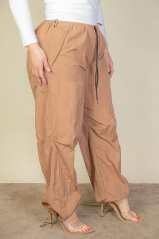 Plus Size Drawstring Waist Parachute Pants in tan, featuring elastic bands and two front pockets for comfort and style.