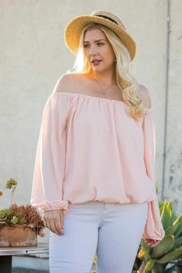 Woman wearing rose off shoulder long bubble sleeve top and straw hat outdoors