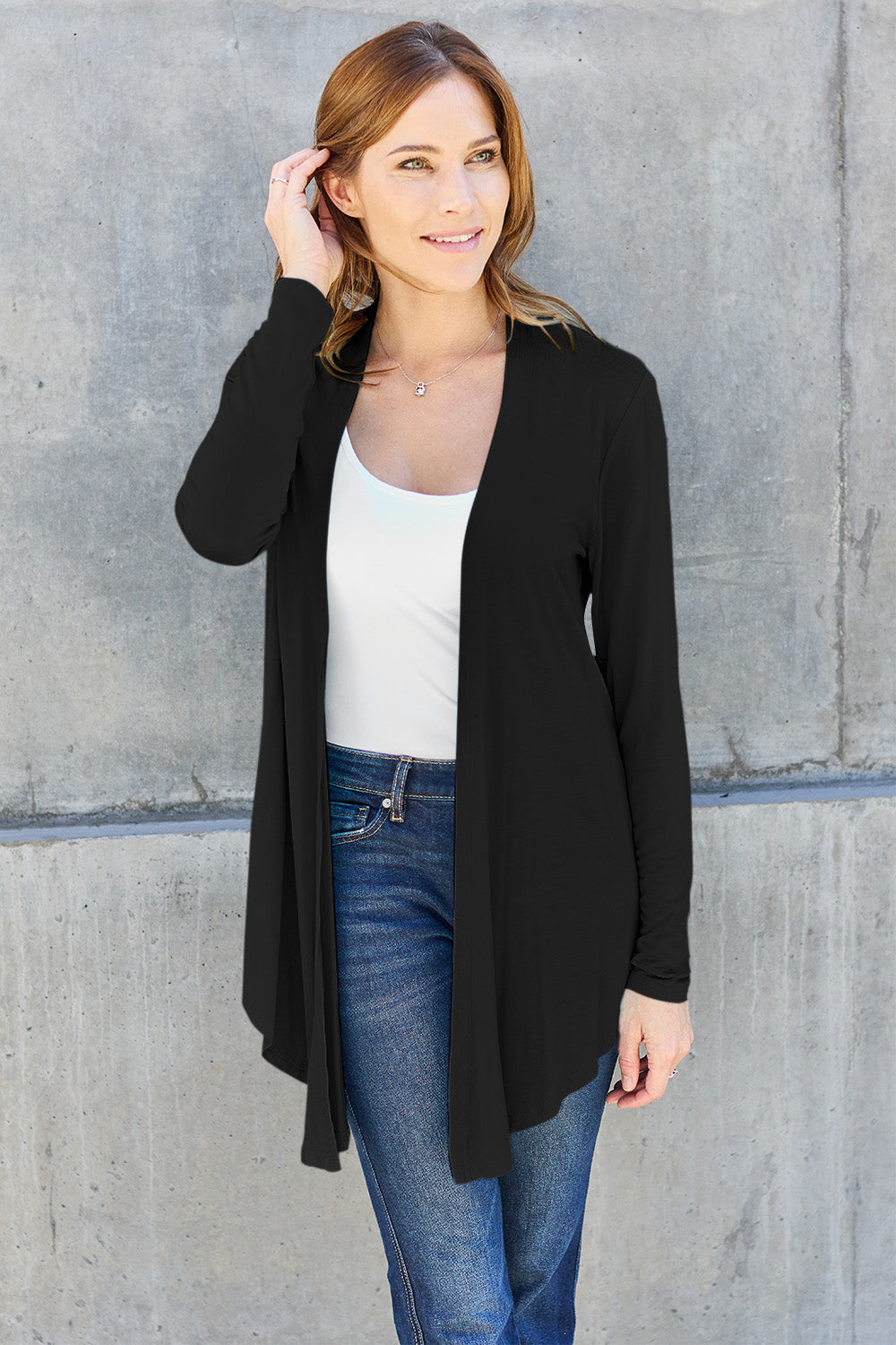 Woman wearing a black open front long sleeve cardigan with jeans, showcasing a stylish and comfortable look.