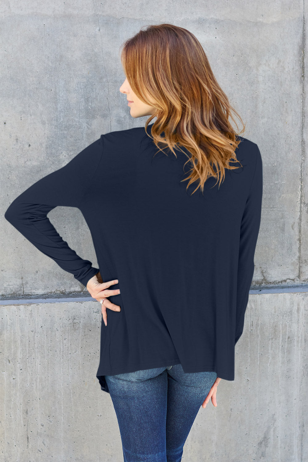 Woman wearing open front long sleeve cardigan made of 95% rayon and 5% spandex, showcasing slightly stretchy basic style.