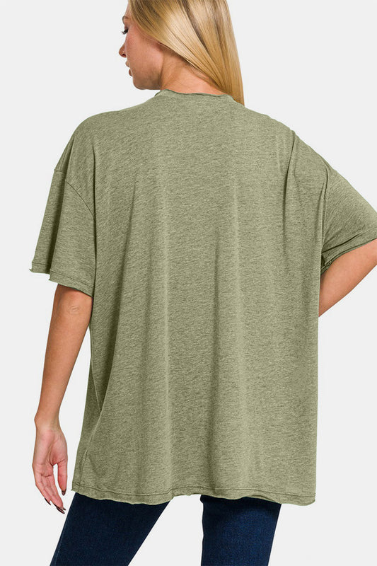 Woman wearing olive green drop shoulder oversized t-shirt with front pocket and no stretch, made of polyester, cotton, and rayon blend.