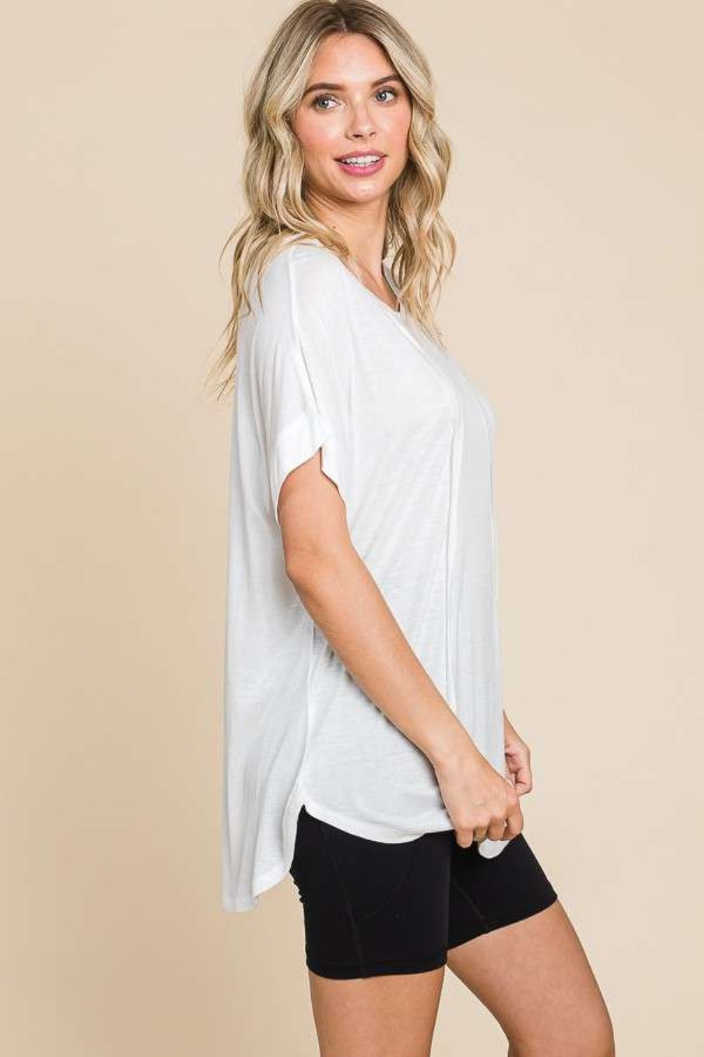 Woman wearing a relaxed fit white round neck short sleeve t-shirt with black shorts, showcasing a versatile wardrobe staple for casual wear.