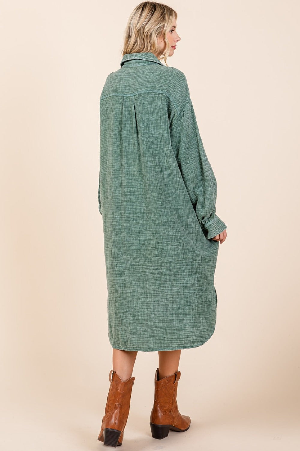 Woman in pine mineral wash cotton gauze midi shirt dress with buttoned back view, paired with brown ankle boots.