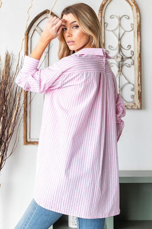 Woman wearing pink striped button-down high-low hem shirt for casual style.