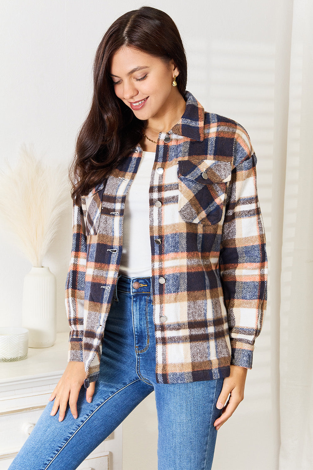 Woman wearing a Double Take Plaid Button Front Shirt Jacket with breast pockets, showcasing classic style and comfortable fit.