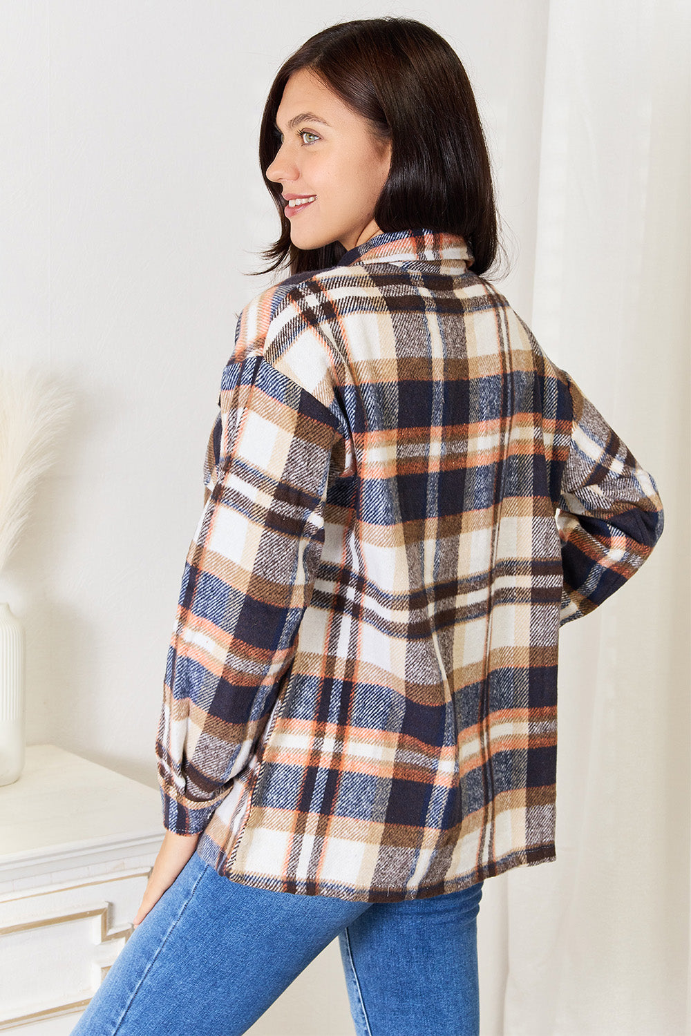 Woman wearing a Double Take Plaid Button Front Shirt Jacket with relaxed fit and breast pockets, showcasing a classic plaid pattern.