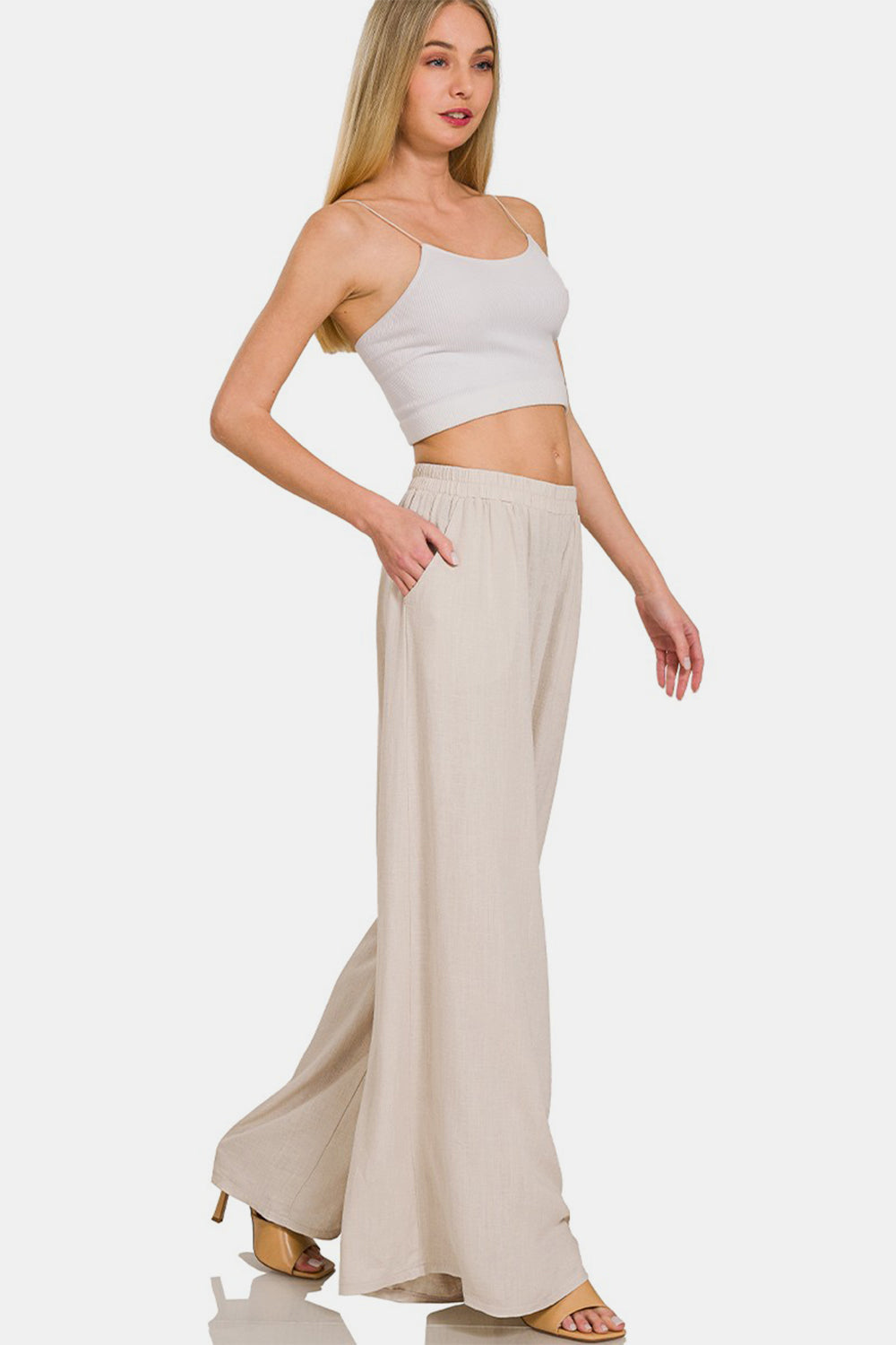 Woman wearing pleated linen blend wide leg pants with pockets, opaque design, 25% linen and 75% rayon for a chic look