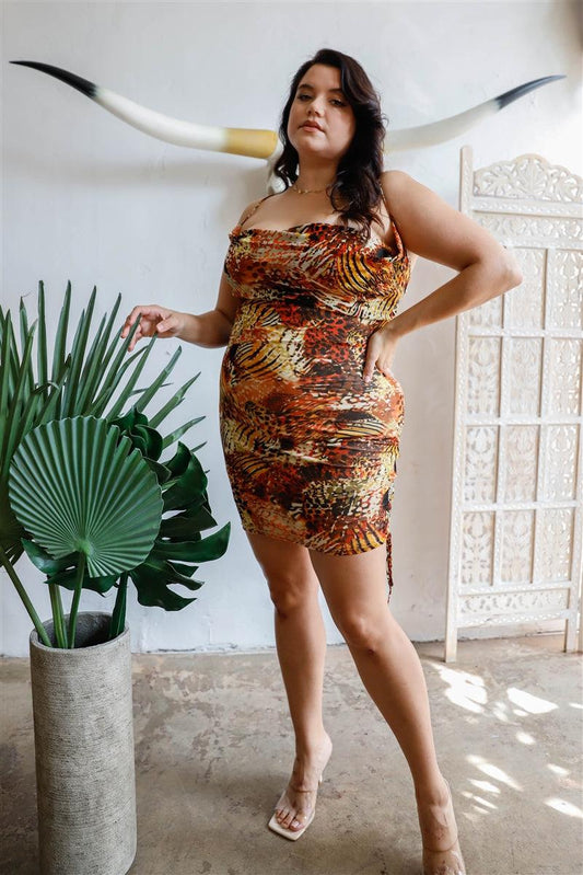 Plus size brown slip mini dress with fall colors, drawstring ruching, cowl neck, and adjustable straps, styled for a night out.