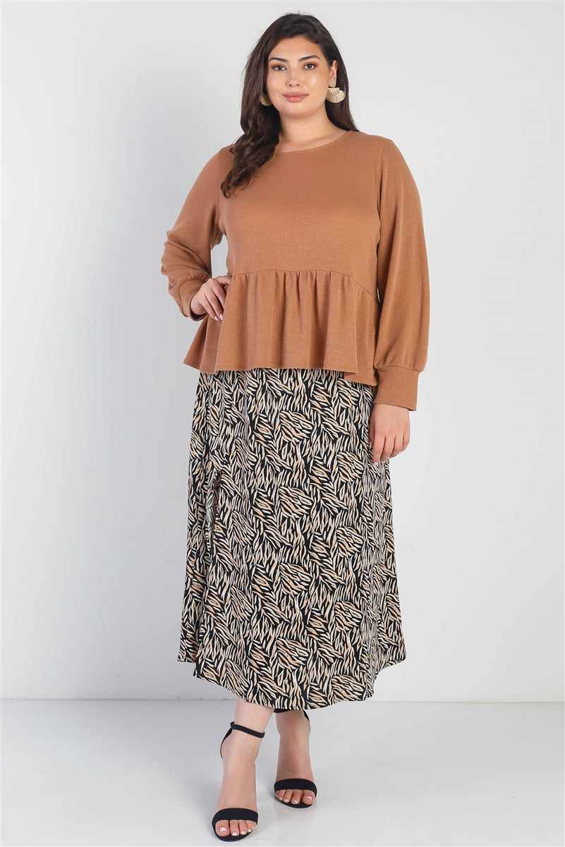 Plus size woman wearing caramel waffle long sleeve top with back button detail and flare hem, styled with black patterned skirt.