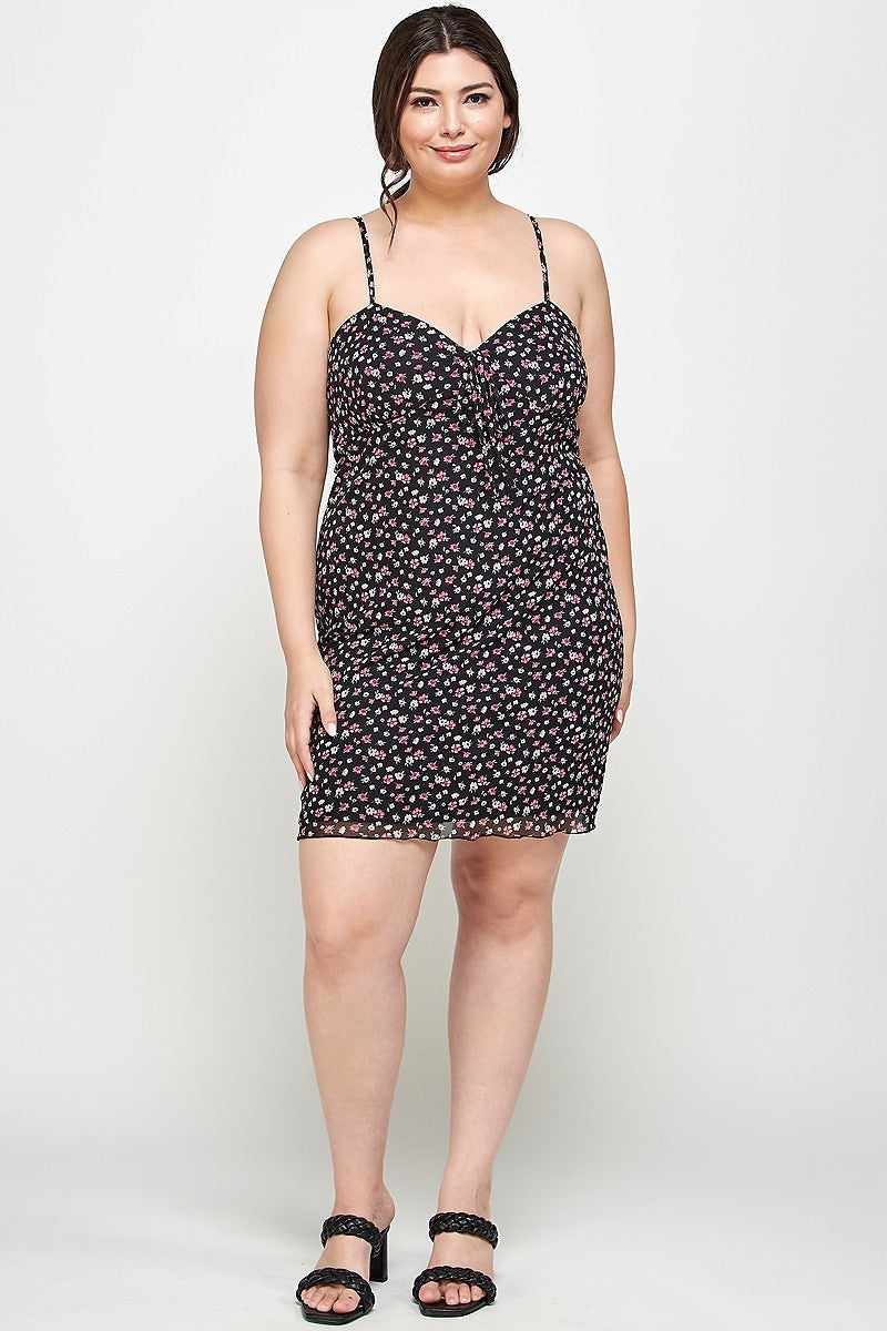 Plus size black ditsy floral cami dress with sweetheart neckline and ruffled hem, featuring a relaxed fit on a model.