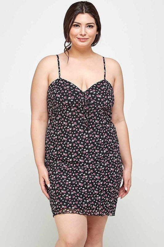 Plus size woman wearing black ditsy floral print cami dress with sweetheart neckline and ruffled hem.