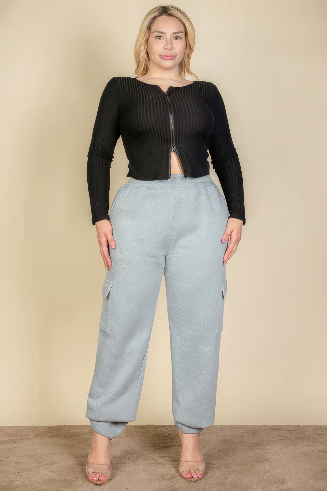Plus size woman wearing gray side pocket drawstring waist sweatpants and black top, showcasing casual fashion style.