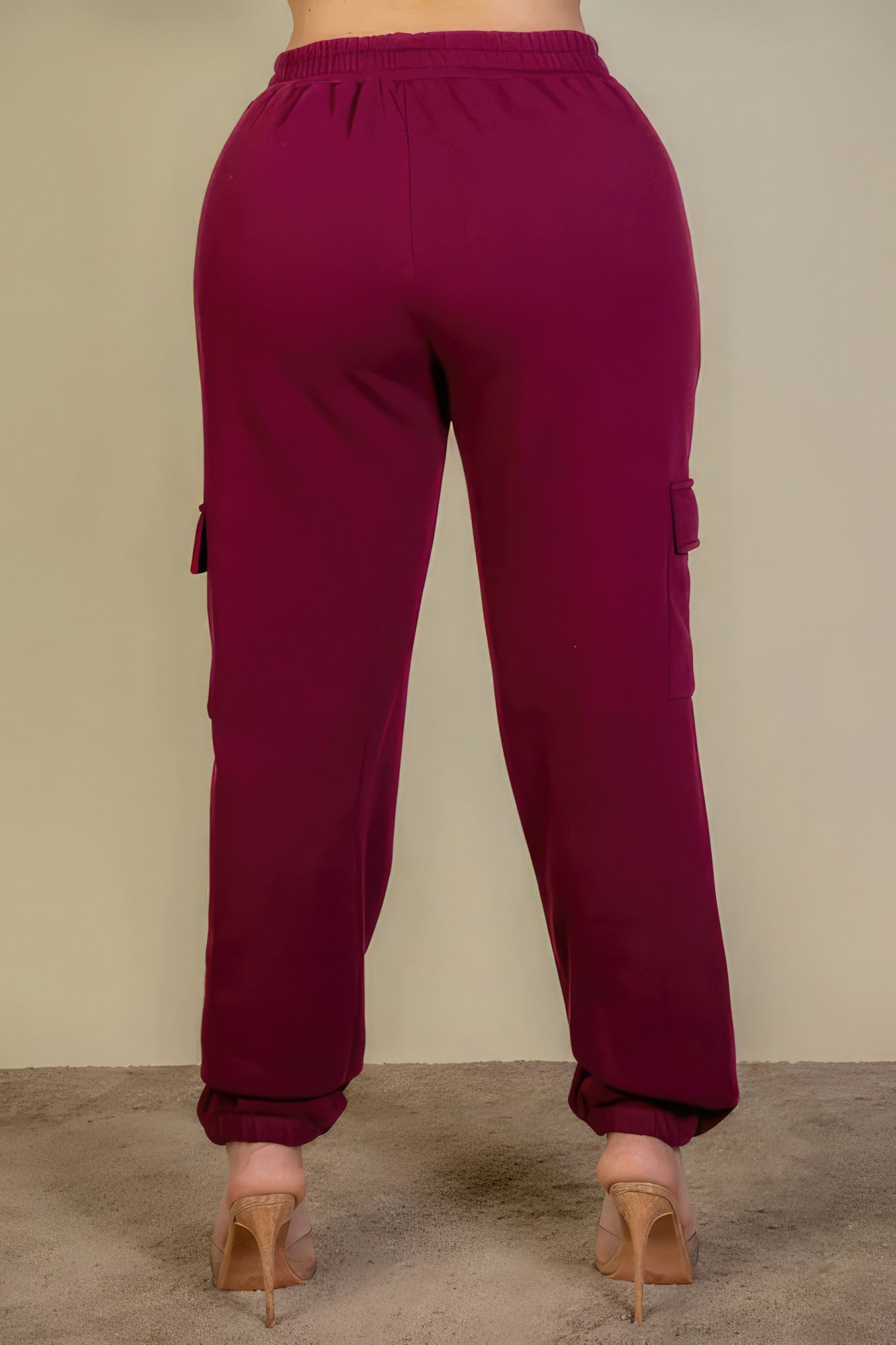 Plus size burgundy sweatpants with side pockets and drawstring waist, back view.