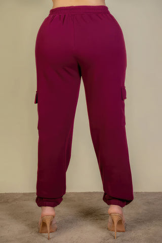 Plus size burgundy sweatpants with side pockets and drawstring waist, back view.