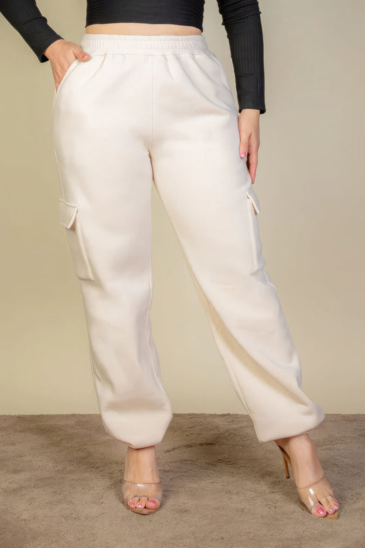 Plus size side pocket drawstring waist sweatpants in white, worn by a person standing on a carpeted floor.