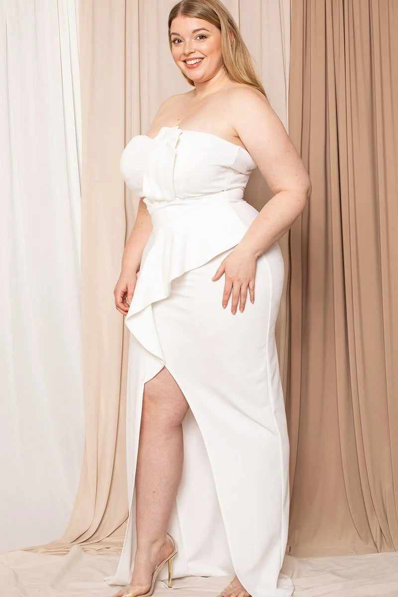 Plus size ivory pleated tube top maxi dress with ruffle and front slit, featuring back zipper, shown on smiling model.